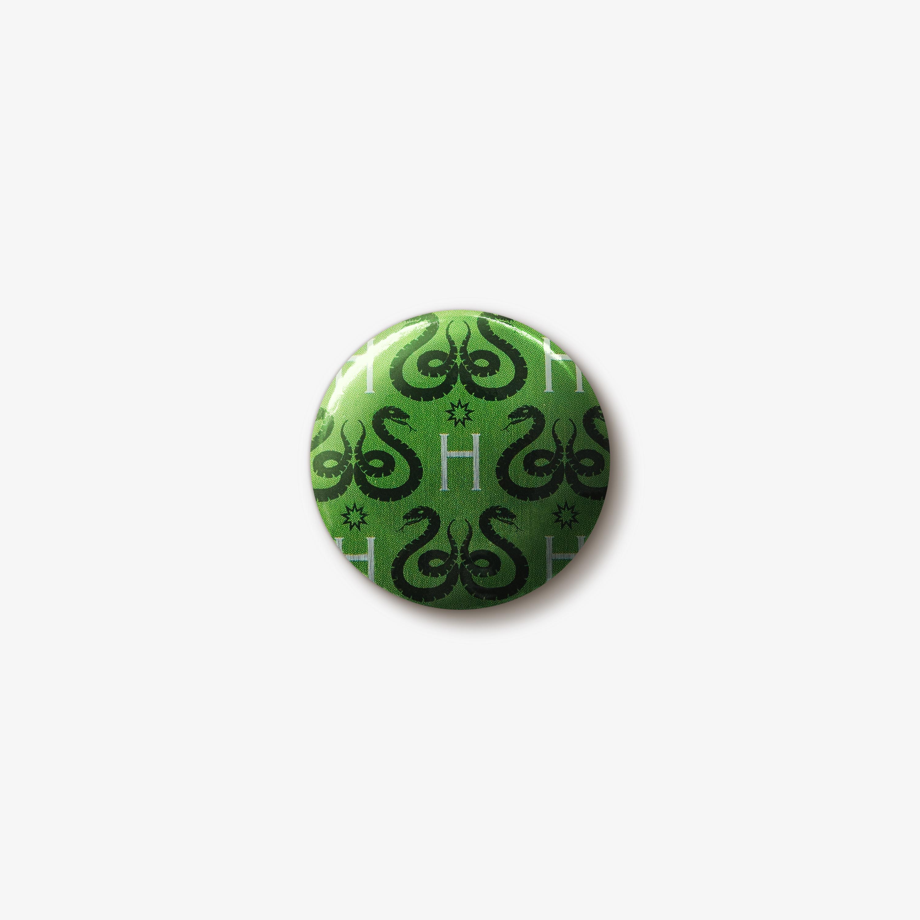 Green button badge with a repeating pattern of black Slytherin snake emblems and silver ‘H’ letters.